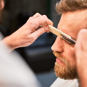 Isolated photo of confident customer on appointment in barbershop.