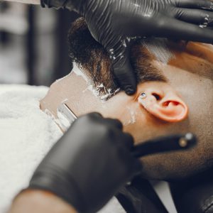 The man cuts his beard in the barbershop